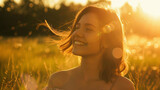 Joyous woman basking in the golden glow of a sunset in a meadow.
