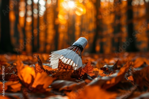 A badminton shuttlecock nestled among autumn leaves in a forest, showcasing the contrast between nature and sports equipment