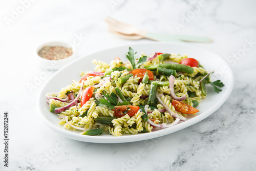 Healthy pasta salad with tomato, pesto sauce and green beans