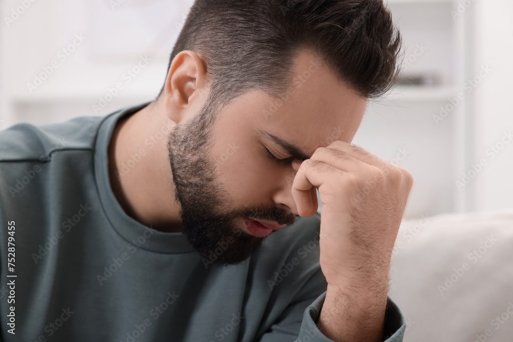 Man suffering from headache at home, closeup Man suffering from headache at home, closeup