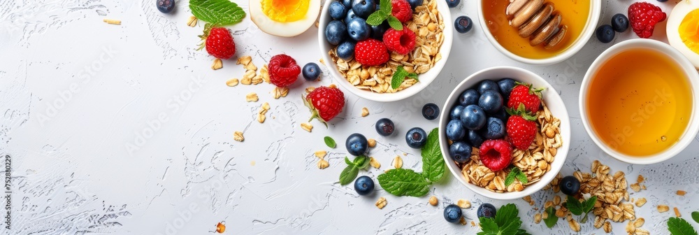 Healthy american breakfast with granola, berries, milk, and honey on white background