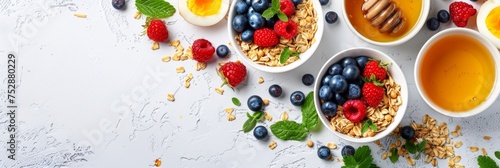 Healthy american breakfast with granola, berries, milk, and honey on white background