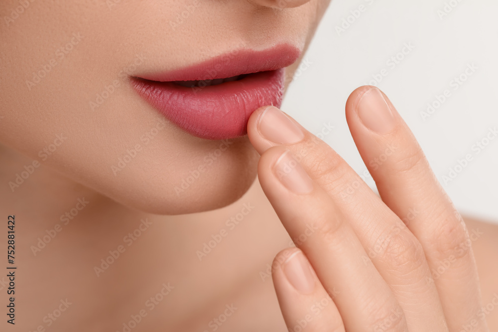 Obraz premium Young woman with beautiful full lips on white background, closeup