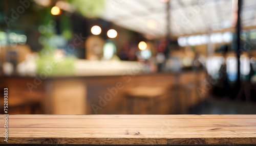 Wood table on blur of cafe, coffee shop, bar, background; empty wooden desktop mock up