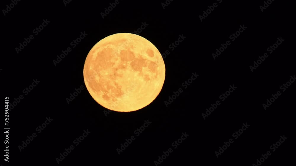 Hunters full moon, orange moonrise with visible craters on the surface. A natural satellite in the dark sky. Hunters full moon, orange moonrise with visible craters on the surface. A natural satellite in the dark sky.