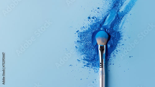makeup brush on a background of blue trendy powder with glitter isolated on a pastel background