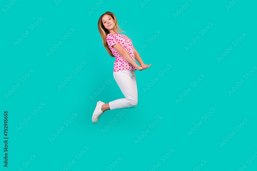 Full body photo of nice teen woman jumping have fun cute pose dressed stylish pink print clothes isolated on aquamarine color background Full body photo of nice teen woman jumping have fun cute pose dressed stylish pink print clothes isolated on aquamarine color background