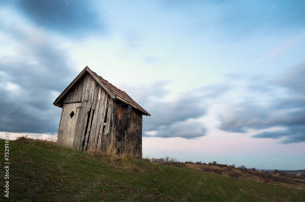 Small hut on a field with long exposure clouds in Burgenland Small hut on a field with long exposure clouds in Burgenland