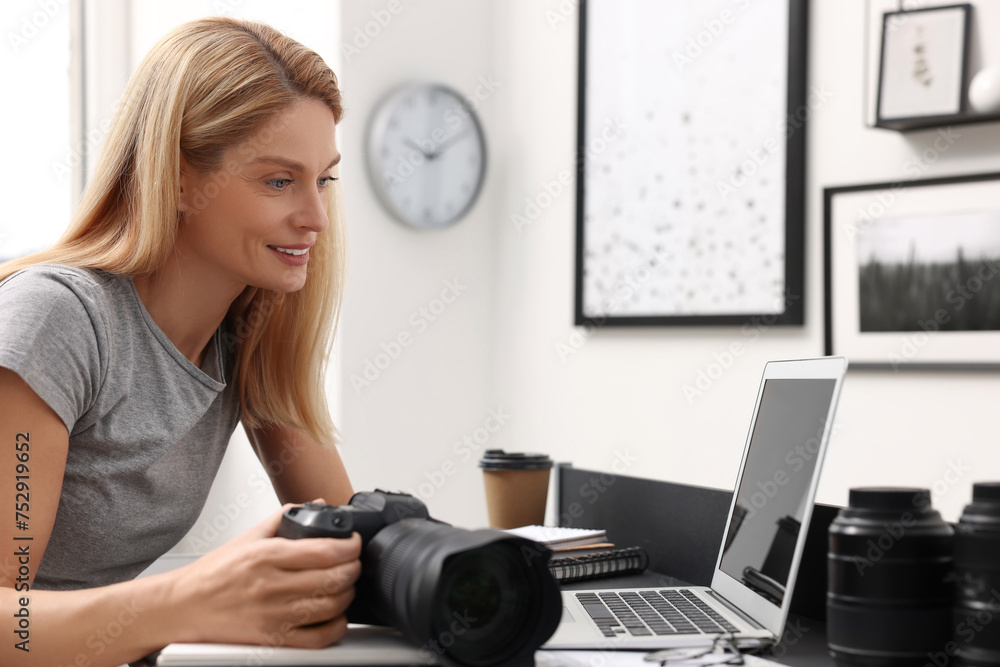 Professional photographer with digital camera at table in office Professional photographer with digital camera at table in office