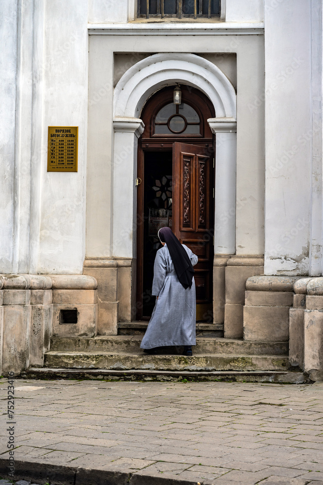 A nun opens the door of an old church