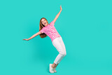 Full length photo of lovely teen lady falling back keep balance dressed stylish pink print garment isolated on aquamarine color background