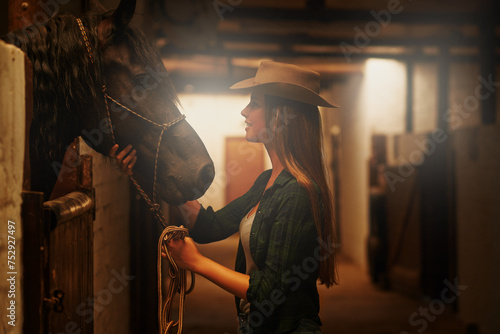 Cowgirl, happy and woman with horse at barn or stable in Texas for recreation. Western, animal and smile of person at ranch with pet or stallion for hobby with care for livestock at equestrian farm © Arcurs Corp/peopleimages.com