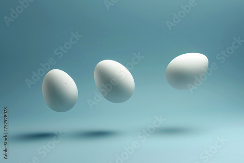 Three white eggs levitating isolated on a light blue background with space for text or inscriptions 