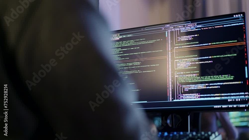 A programmer is immersed in a late night coding session, with code filling up dual monitors, reflecting the dedication common in tech industries.