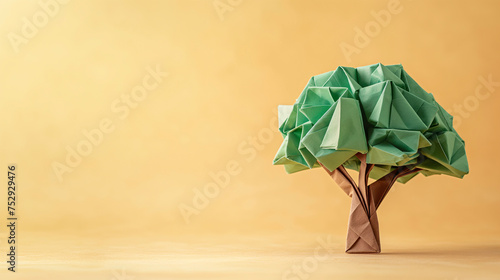 Arbol hecho con papel técnica origami sobre fondo naranja photo