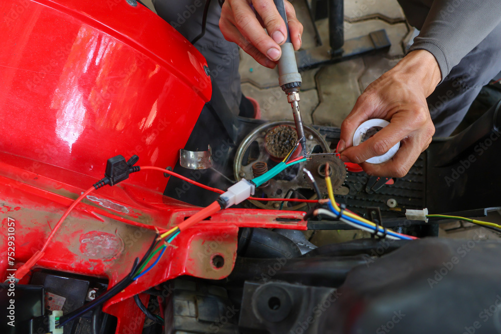selective focus wires in the hand of a car mechanic Practicing repairs to the ATV's electrical system. Wires of various colors help you know the direction of your car's electrical system.