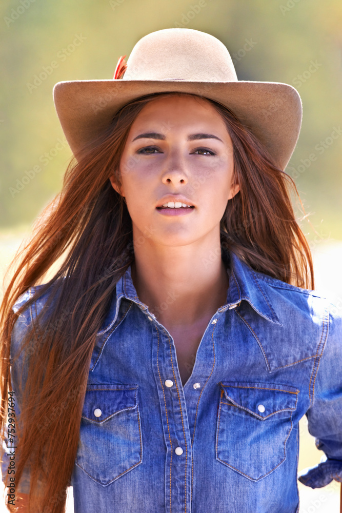 Cowgirl, portrait and hat at farm, field and western fashion for agriculture, work and outdoor in summer. Woman, person and farmer at ranch for sustainability, countryside and environment in Texas