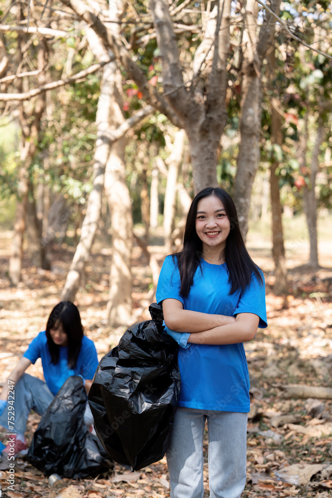 Volunteer collecting plastic trash in the forest. The concept of environmental conservation. Global environmental pollution. Cleaning the forest Volunteer collecting plastic trash in the forest. The concept of environmental conservation. Global environmental pollution. Cleaning the forest
