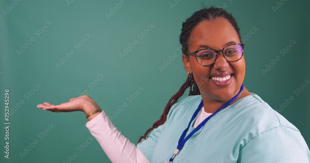Young Black female nurse holds up hand, smiling Young Black female nurse holds up hand, smiling