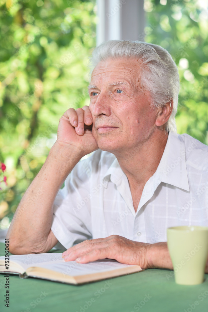 Portrait of senior man reading book with tea Portrait of senior man reading book with tea