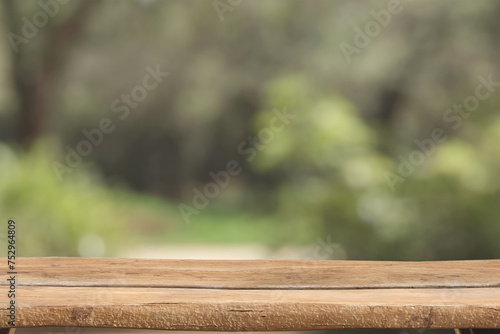Wooden rustic table top on blurred park background © S_Designs
