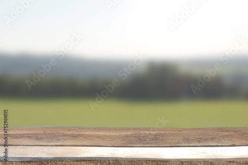 Wooden rustic table top on blurred greenery background