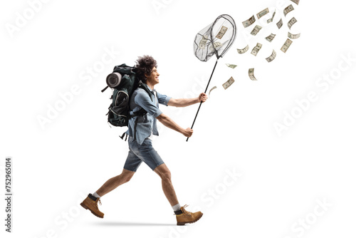 Full length profile shot of a backpacker running after money with a catching net photo