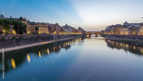 River Arno and bridge Ponte Vecchio day to night transition timelapse after sunset from Ponte alle Grazie in Florence, Tuscany, Italy. Lights reflections on the river with evening illumination photo