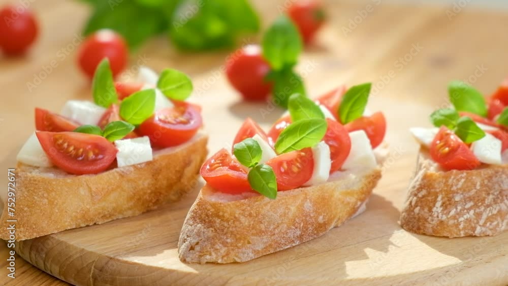 Caprese bruschetta with tomatoes, mozzarella cheese and basil in sun rays on wooden board. Traditional Italian appetizer, snack or antipasto. Vegetarian food. Healthy eating. Mediterranean food. Caprese bruschetta with tomatoes, mozzarella cheese and basil in sun rays on wooden board. Traditional Italian appetizer, snack or antipasto. Vegetarian food. Healthy eating. Mediterranean food.