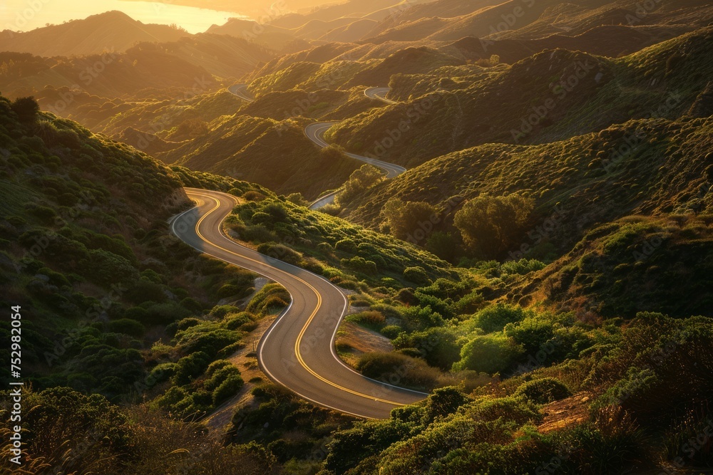 A winding road in a mountainous landscape during sunset.