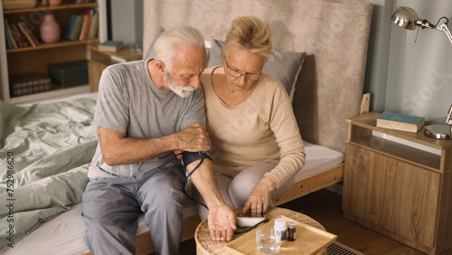 Senior couple measuring blood pressure at home