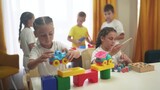 child group playing fishing. children in kindergarten play with toys. happy family kid lifestyle dream concept. a group of children collect building blocks in a kindergarten indoors