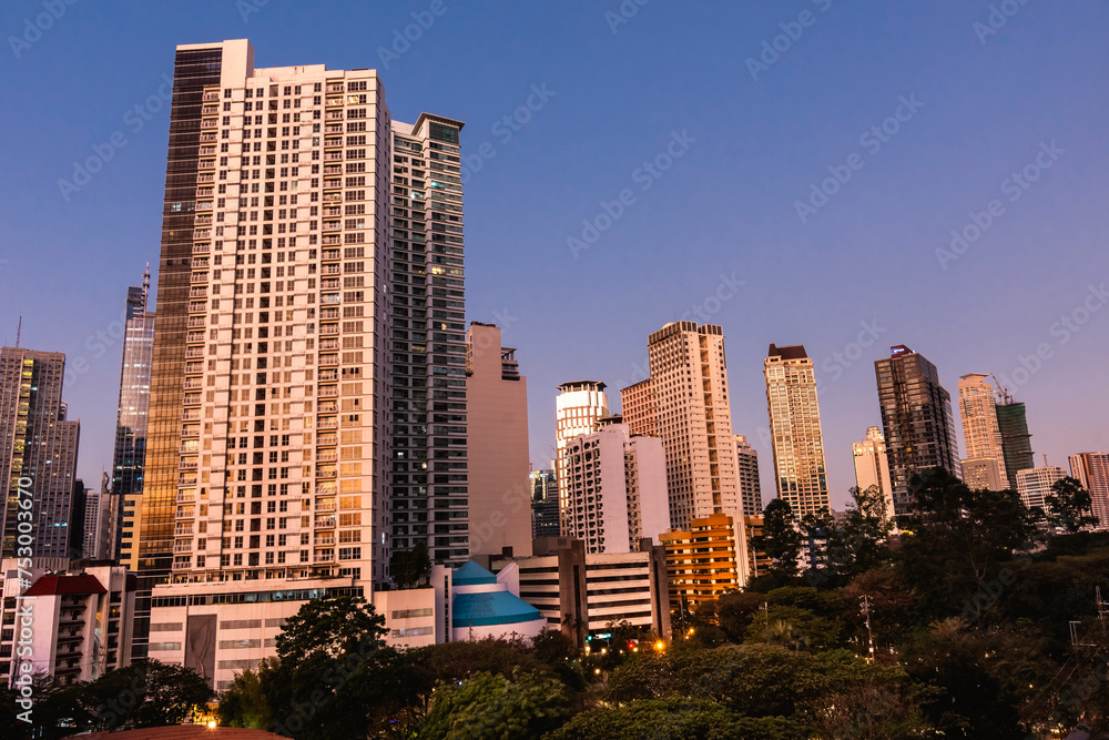 Fototapeta premium Makati, Philippines - Luxury condominiums along Washington Sycip Park in Legaspi Village during a warm sunset.