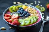 A smoothie bowl topped with sliced fruits and nuts ready for breakfast
