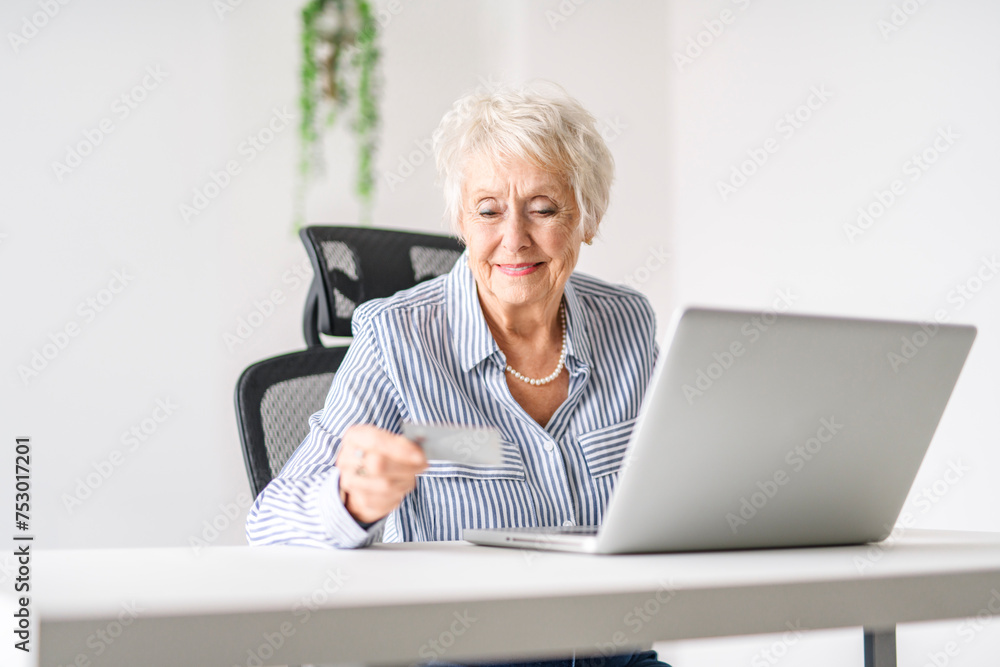 senior women using a laptop while sitting at the office senior women using a laptop while sitting at the office
