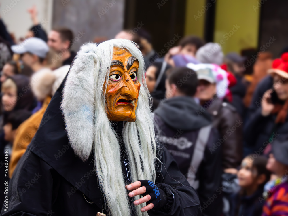 Freiburg in Breeisgau, Germany - February 12, 2024: Masquerade. Beautiful mask in a carnival parade with people blurred in background.