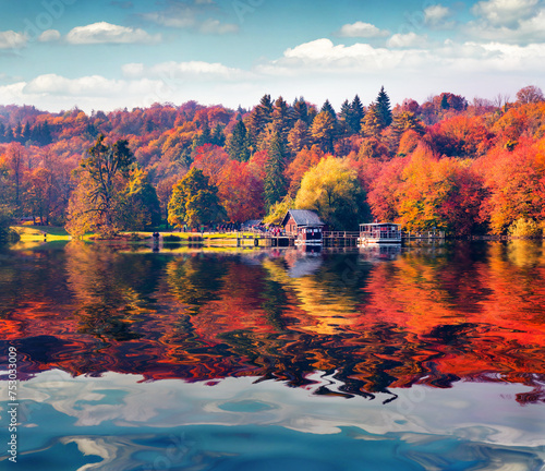 Lush foliage trees relected in the calm waters of Plitvice lake. Bright Colorful autumn landscape of Croatia, Europe. Traveling concept background.