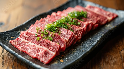 A platter of thinly sliced yakiniku beef sprinkled with green onions, marbled with fat and ready to be grilled, poster