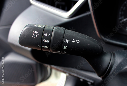 The light knob in the car. Multifunction Headlight Console Control Switch knob. Car interior with light switch. Headlight switch; Turn signal lever; Fog light switch.