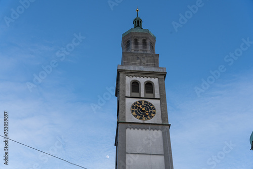 A tall clock tower with a green spire and a clock face