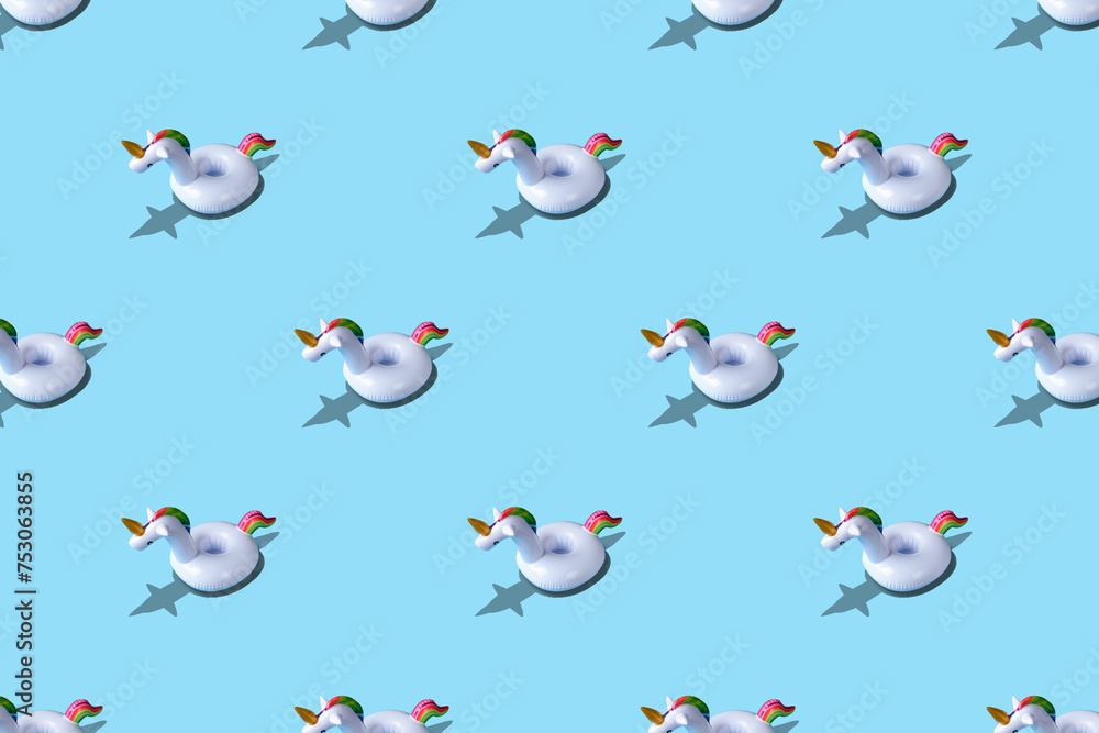 Inflatable unicorn pool toy pattern on blue background. Minimal summer concept.
