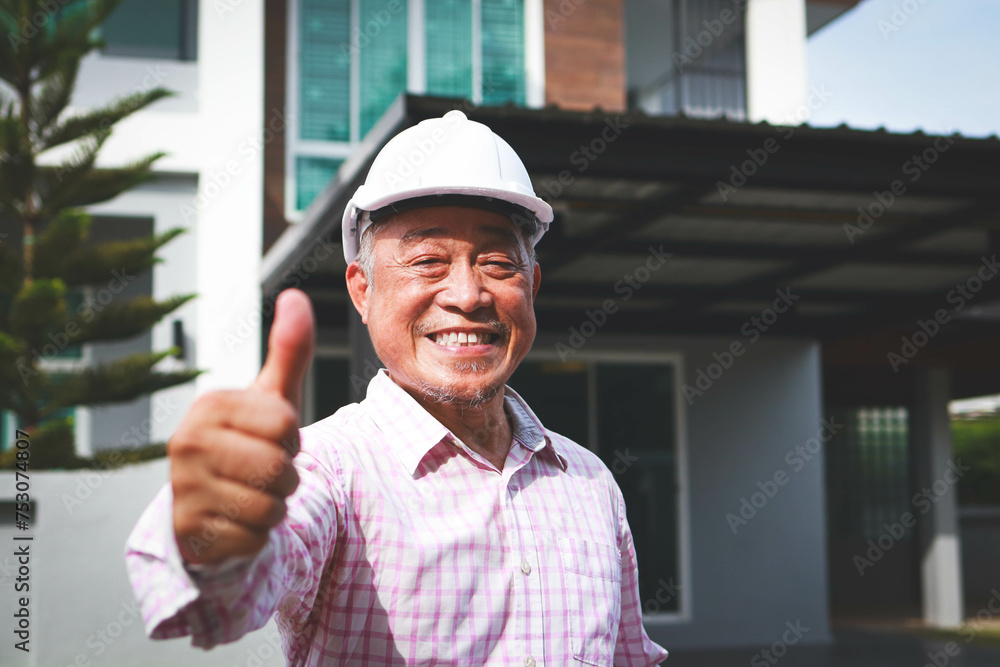 Home construction contractor gives thumbs up He smiled happily. Elderly engineer or architect wearing a white hard hat. Real estate business. copy space Home construction contractor gives thumbs up He smiled happily. Elderly engineer or architect wearing a white hard hat. Real estate business. copy space