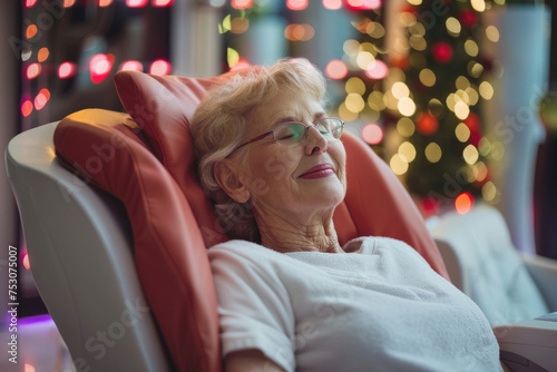 happy senior woman relaxing during pressotherapy at the spa photo