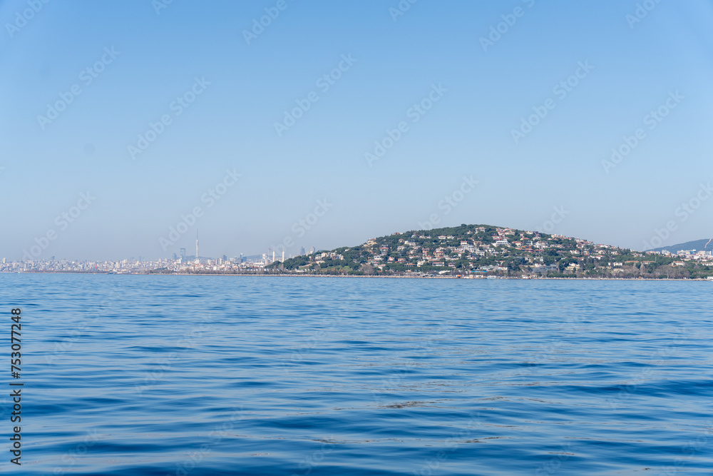 A calm blue ocean with a city in the background