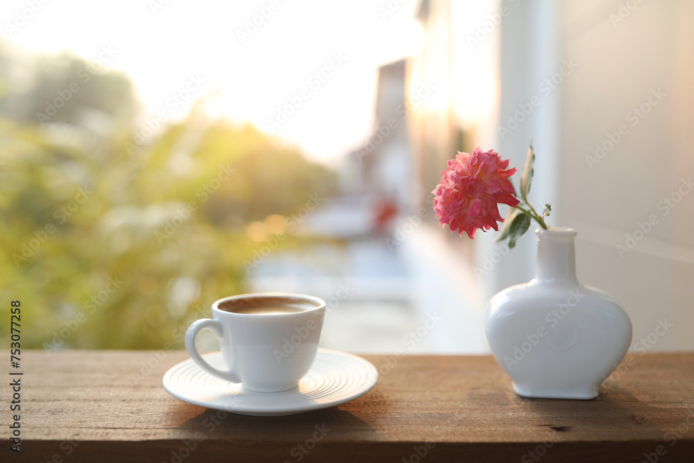 ceramic coffee cup and a white vase of rose flowers ceramic coffee cup and a white vase of rose flowers
