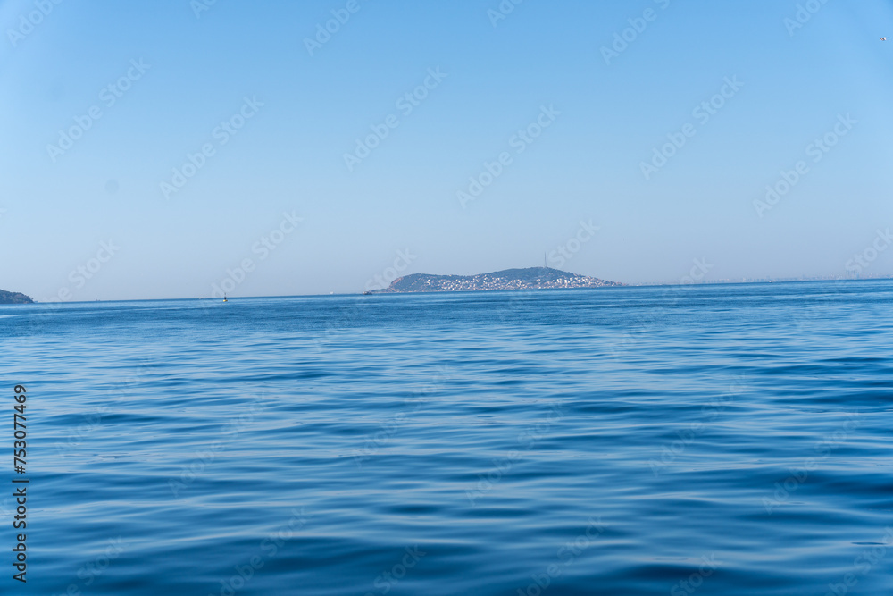 Obraz premium The ocean is calm and blue, with a small island in the distance