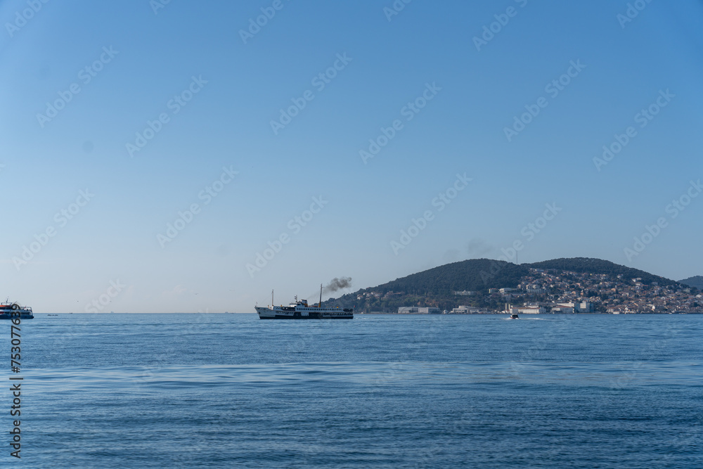 A boat is sailing in the ocean with a blue sky in the background