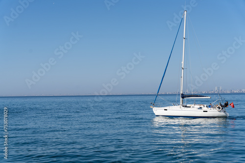A sailboat is floating on the water in a calm sea