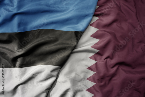 big waving national colorful flag of qatar and national flag of estonia.