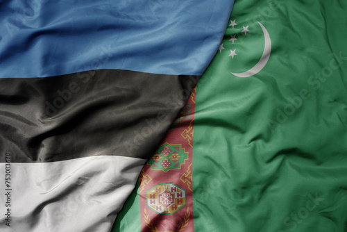 big waving national colorful flag of turkmenistan and national flag of estonia.